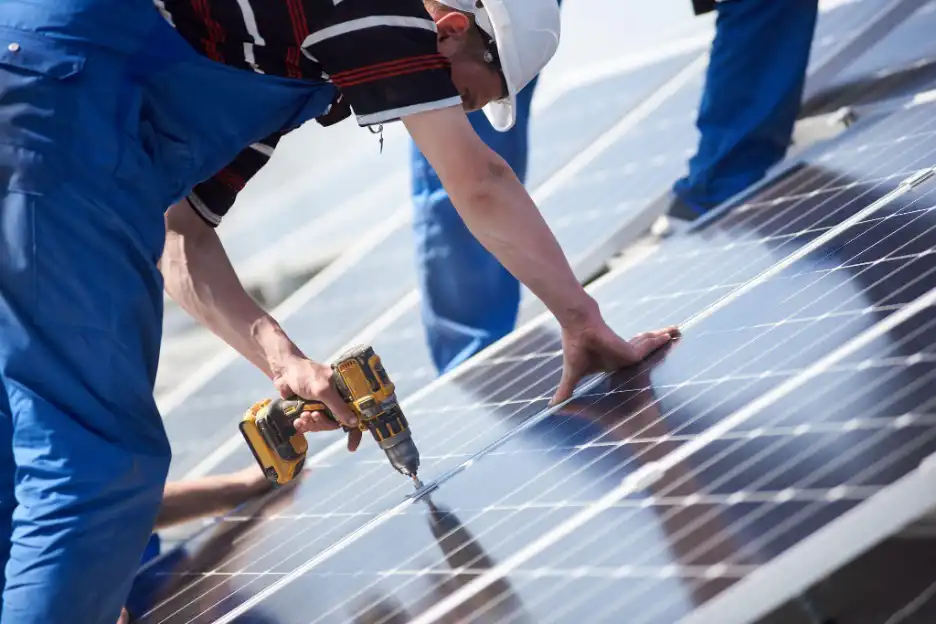 Technician installing solar panels on a roof